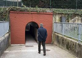 Un viandante junto a la entrada del paso subterráneo.