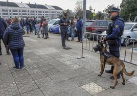 El agente Ismael Abascal, sujetando a su perro, Turko, en los accesos al pabellón Vicente Trueba de Torrelavega.