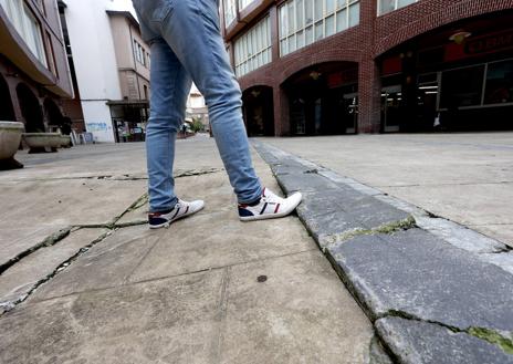 Imagen secundaria 1 - El pavimento presenta numerosas roturas y hundimientos y el asadizo y entrada a los garajes, junto a la calle Ruiz Tagle, también presena desperfectos.