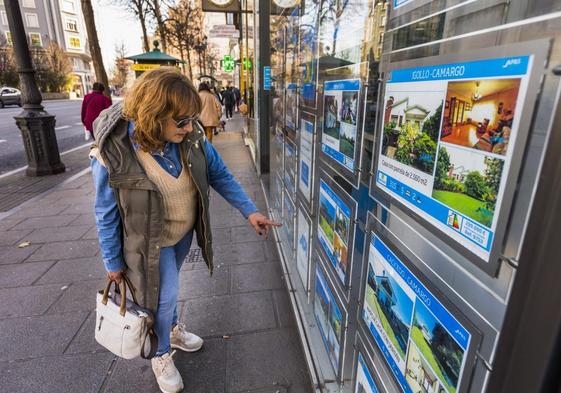 Una mujer contempla la oferta de viviendas en una agencia inmobiliaria de Santander.