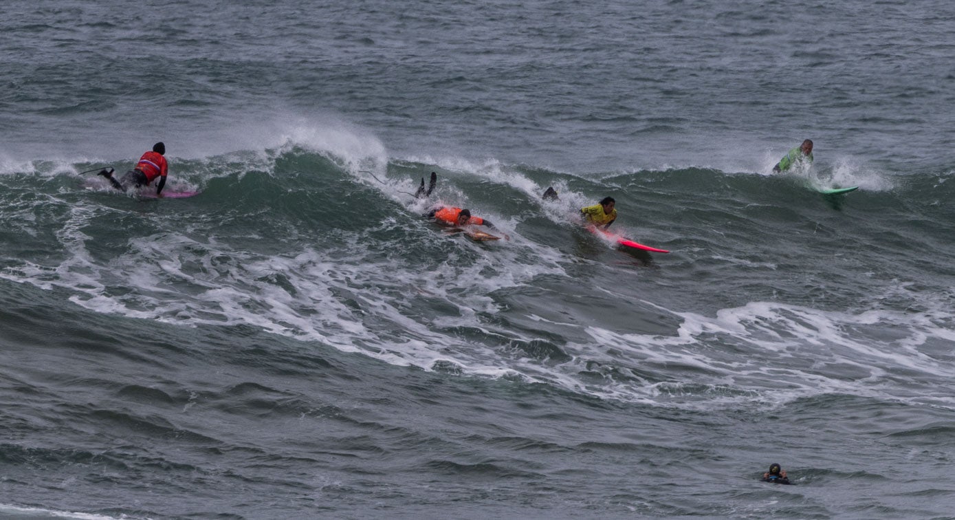 Hasta cuatro surfistas buscan las posiciones en plena competición.