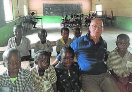 El misionero salesiano Carlos Berro posa con los alumnos de la escuela de Yuna.