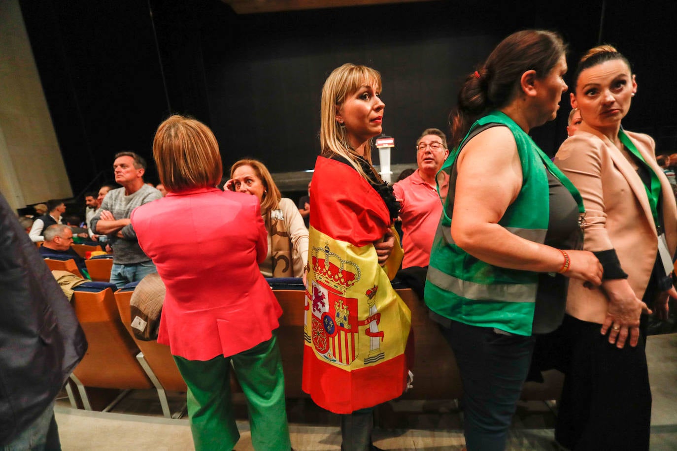 Una mujer acudió al acto abrazando la bandera de España.