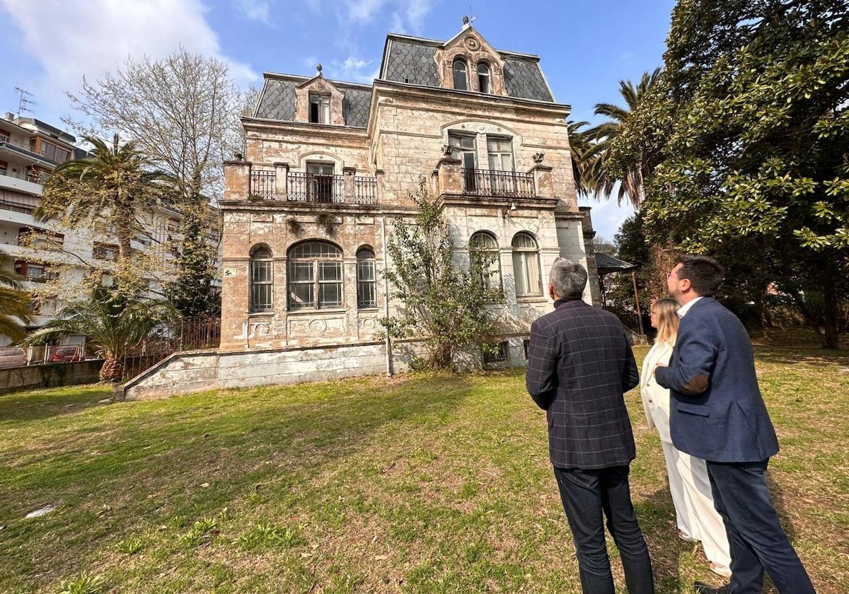 El vicepresidente de Cantabria, Pablo Zuloaga, la consejera de Empleo y Políticas Sociales, Eugenia Gómez de Diego, y el alcalde de Colindres, Javier Incera, contemplan el edificio de Villa Luz desde el interior de la finca.