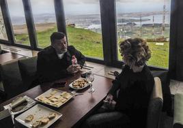 Un hombre y una mujer degustan un aperitivo rodeados de la panorámica que ofrece Peña Cabarga.