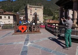 Wences Rodríguez saca una foto a unos turistas en la ventana abierta al mundo que su fundación ha instalado en Potes.