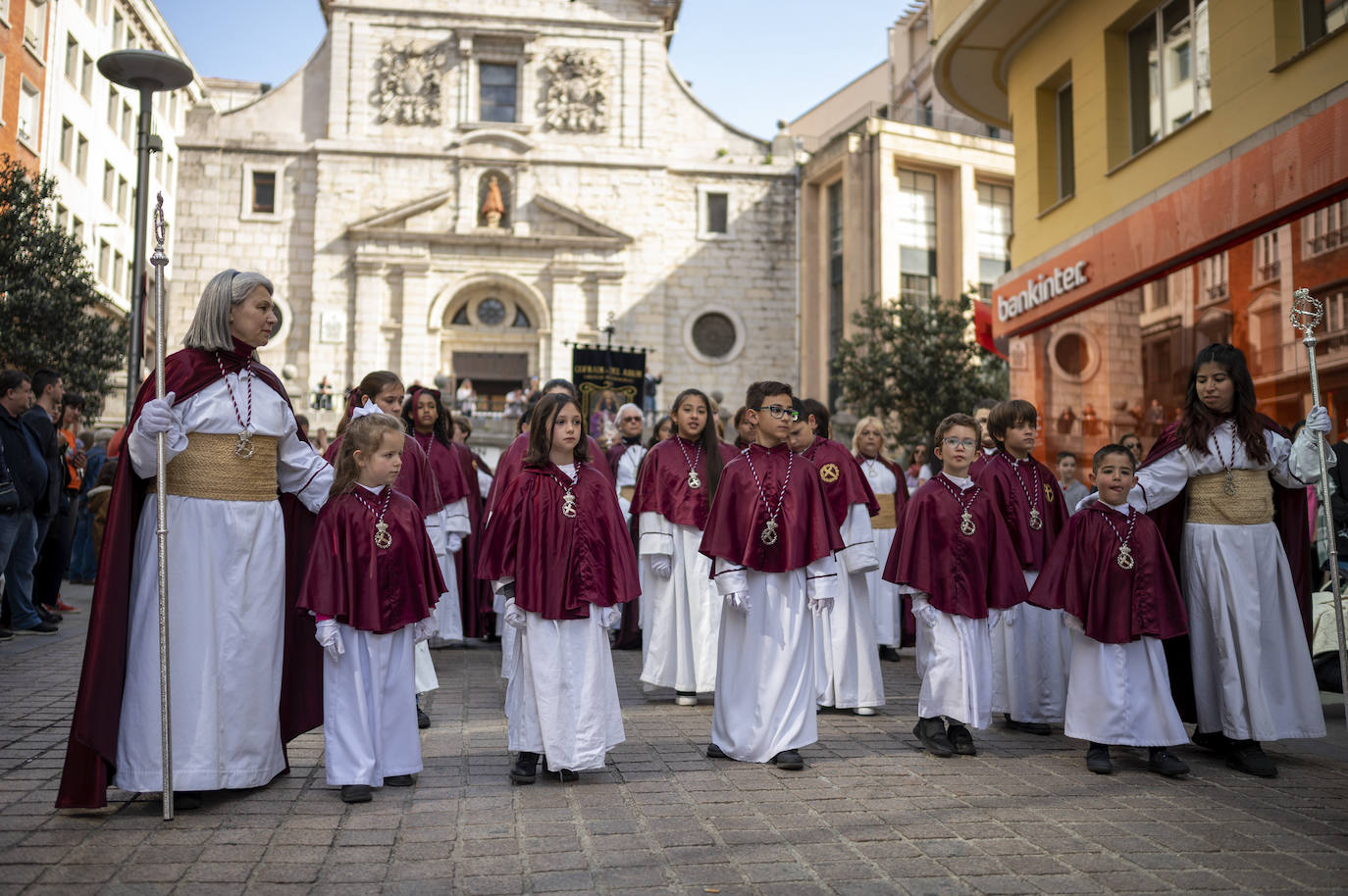 Niños de la Cofradía de la Salud pasan por delante de la iglesia de la Anunciación.