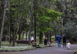 Vecinos caminan por el parque Manuel Barquín, este martes, en Torrelavega