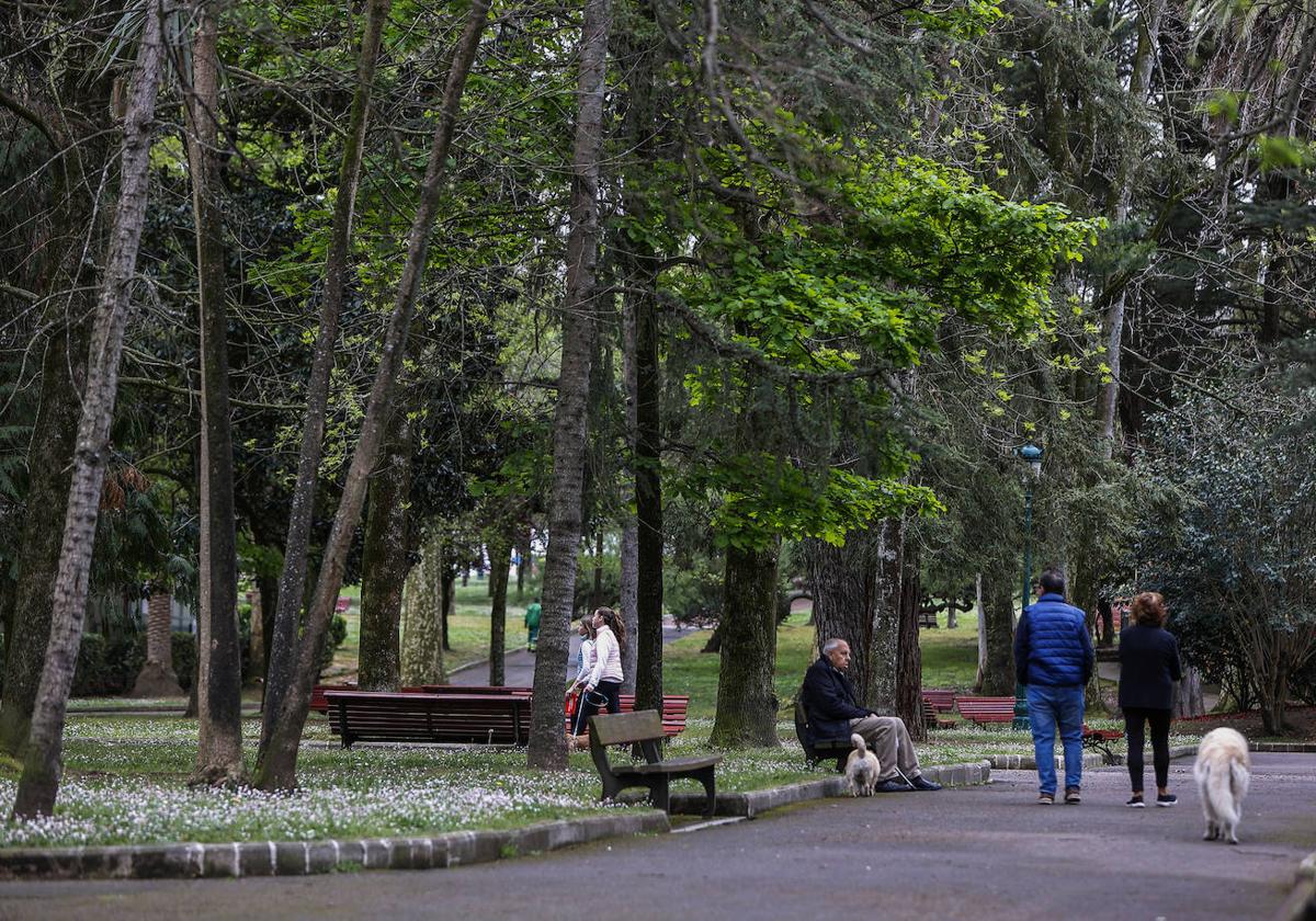 Vecinos caminan por el parque Manuel Barquín, este martes, en Torrelavega