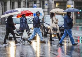 Los gorros de lluvia, los abrigos y la ropa de abrigo vuelven a las calles, como en esta fotografía de este miércoles en el centro de Santander.