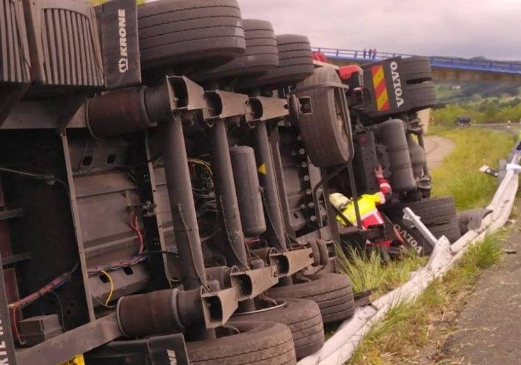 Imagen principal - Liberan a un camionero atrapado en la cabina tras volcar en la A-8