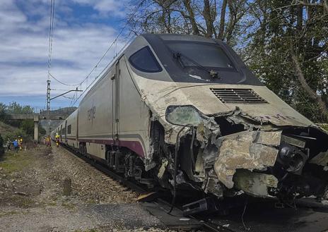 Imagen secundaria 1 - Estado es que ha quedado la máquina del Alvia tras el choque. Los viajeros del tren han sido ayudados por los bomberos.