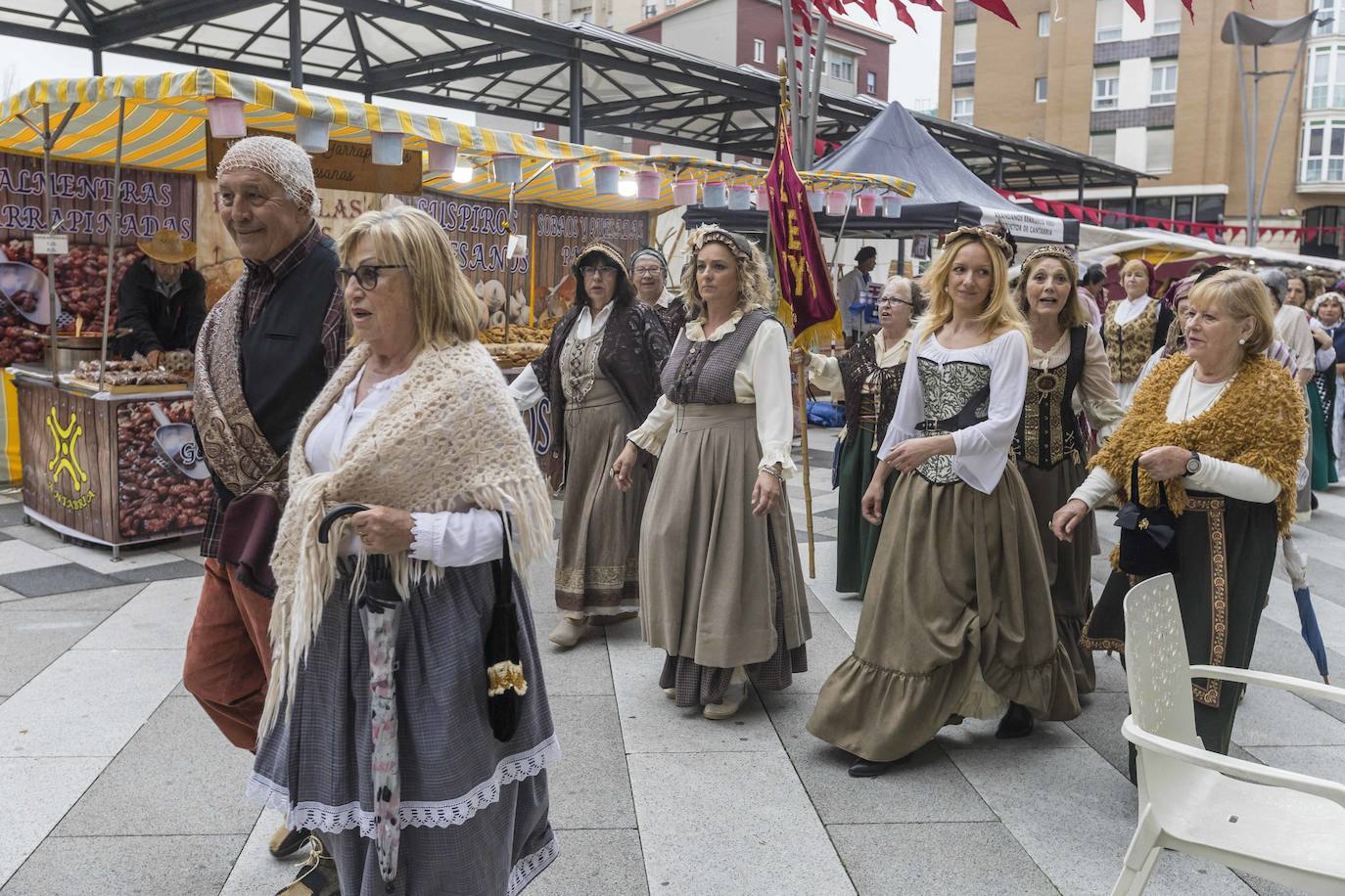 Mujeres y hombres, ataviados con el traje de época de la España campesina y sencilla. 