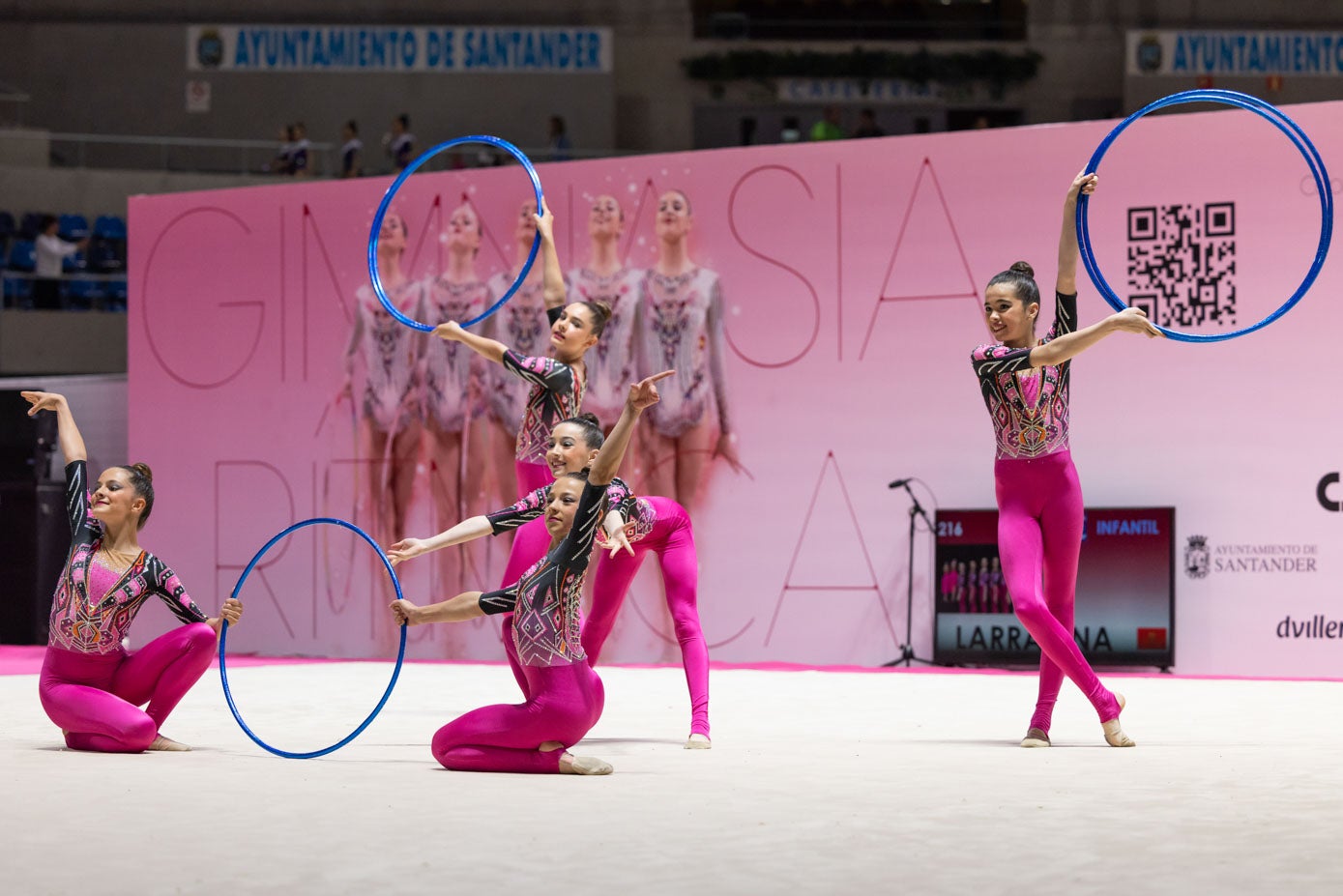 Cinco gimnastas, con sus aros en un momento de la competición.