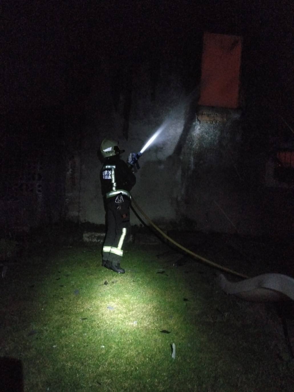 Un bombero, atacando las llamas de la vivienda de Navajeda.