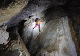 Un espeleólogo baja haciendo rappel por uno de los cortados que asoman en el interior del Sistema Mortillano.