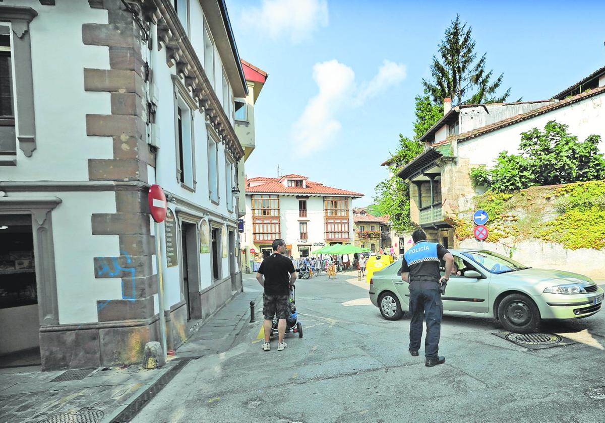 Un agente de la Policía Local regula el tráfico en una de las calles del casco urbano de Comillas.