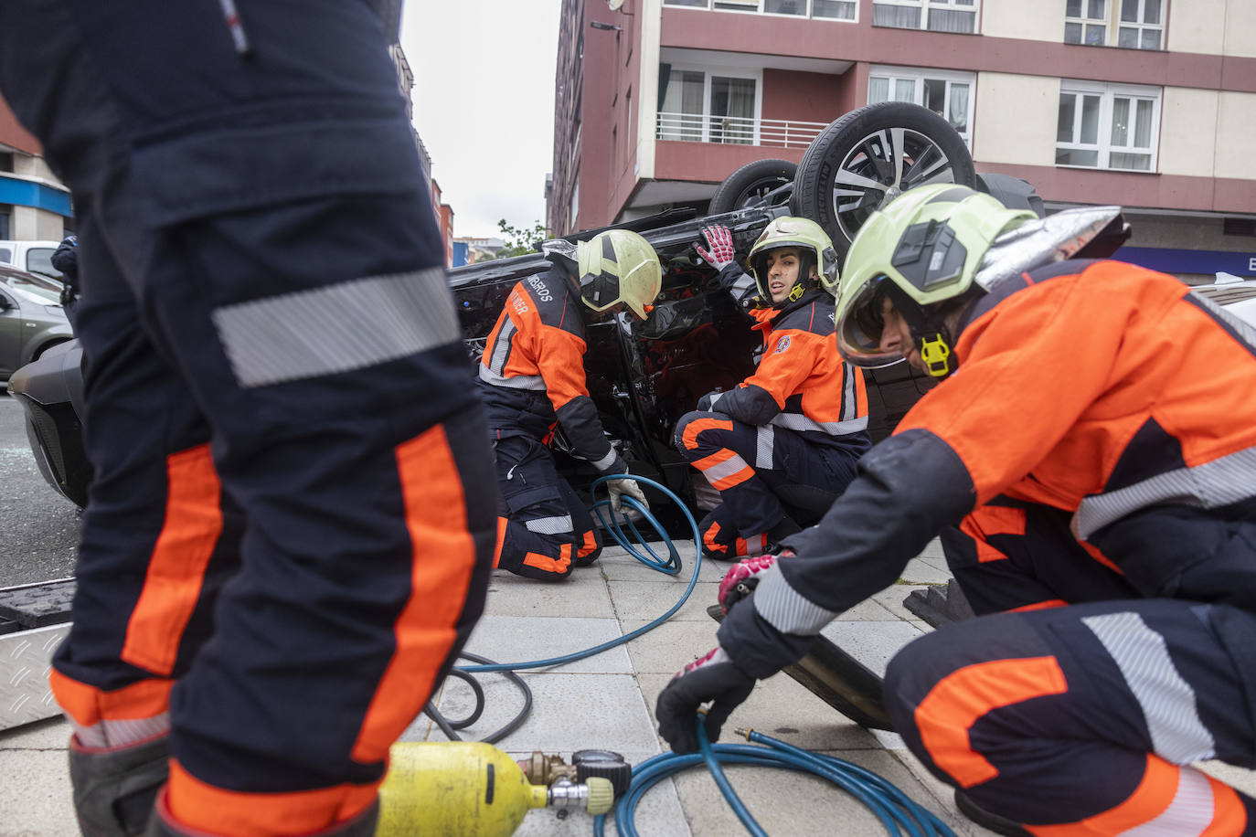 Los bomberos preparan la maniobra para dar la vuelta al vehículo volcado.