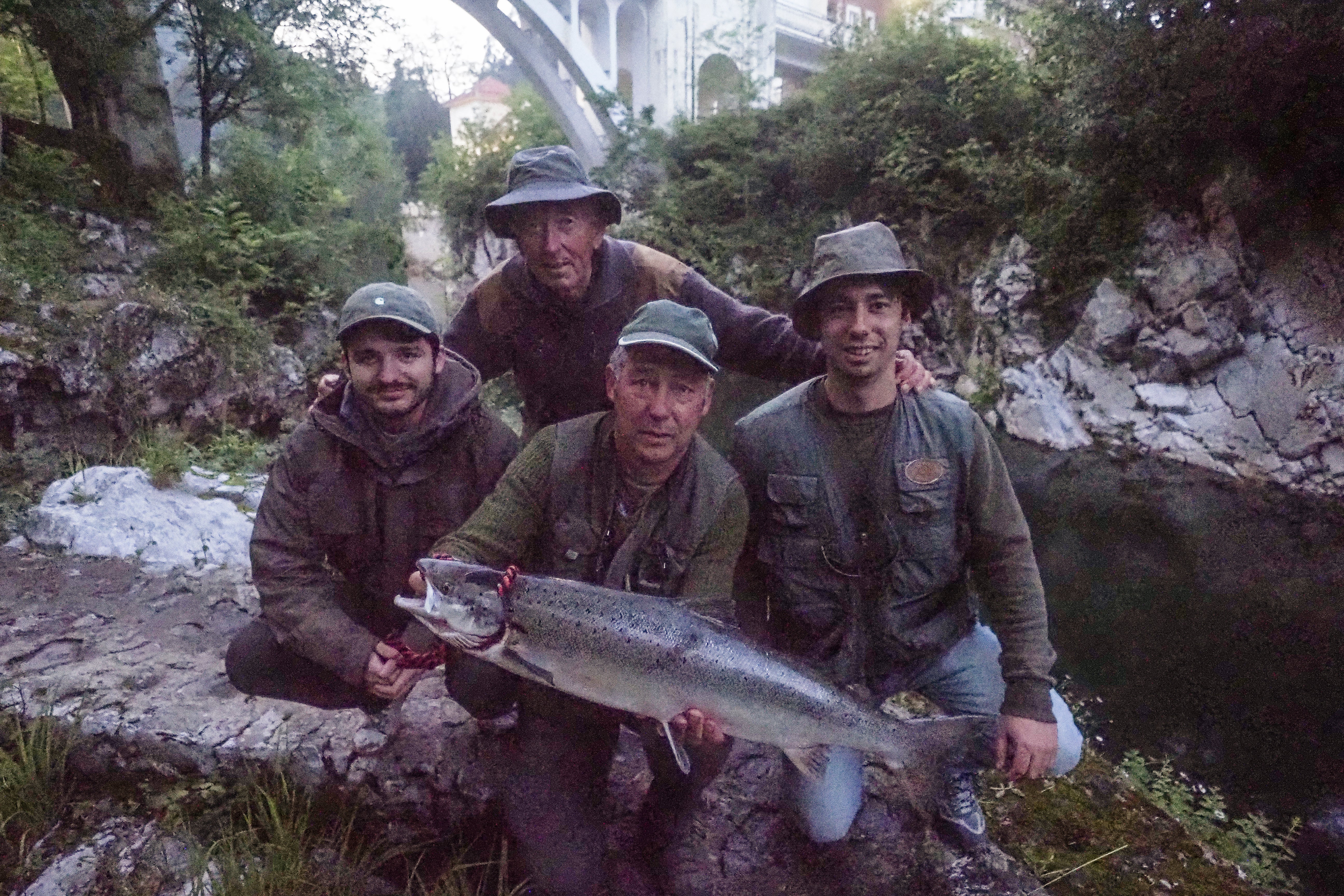 El pescador José Armando Devesa Piñera sostiene el 'campanu' junto a sus hijos y al ribereño Ángel Fernández 'Gelín el pasiego'.