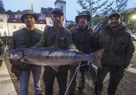 El pescador José Armando Devesa Piñera sostiene el 'campanu' junto a sus hijos y al ribereñero Ángel Fernández 'Gelín el pasiego'.