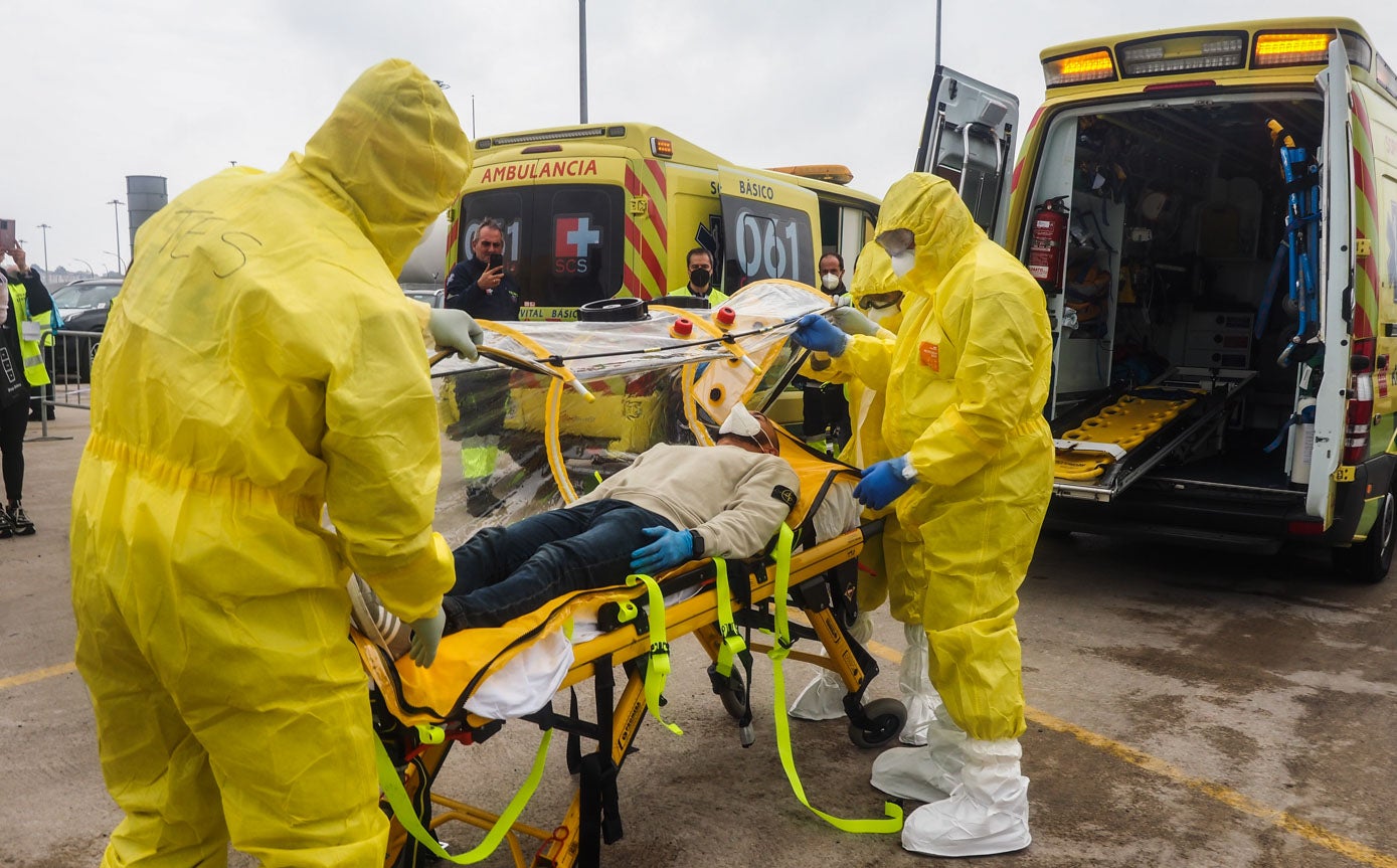 Los sanitarios del 061, vestidos con Epis, evacúan a los infectados.