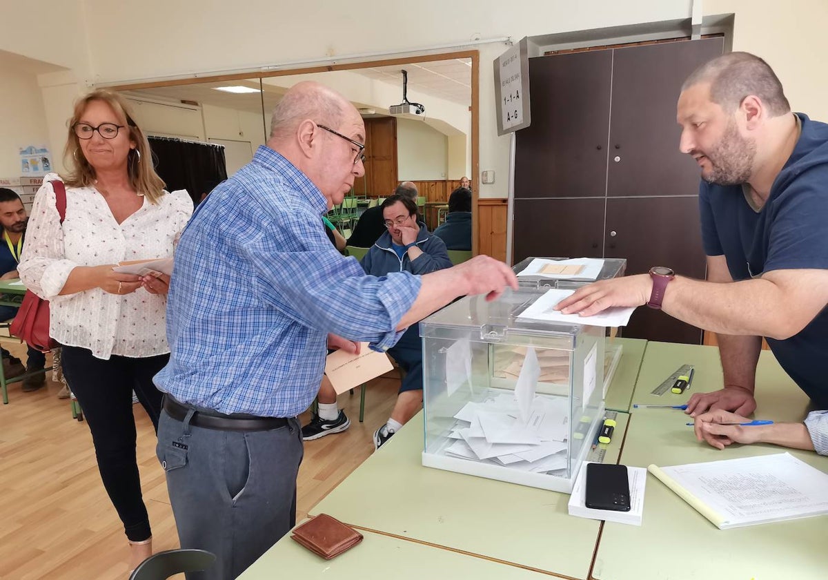 Un vecino introduce su voto en la urna de uno de los colegios electorales de Cabezón.