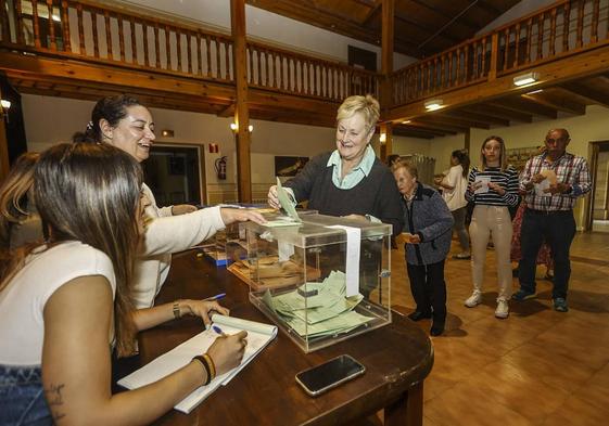 Ciudadanos votan en una mesa electoral en Reocín.