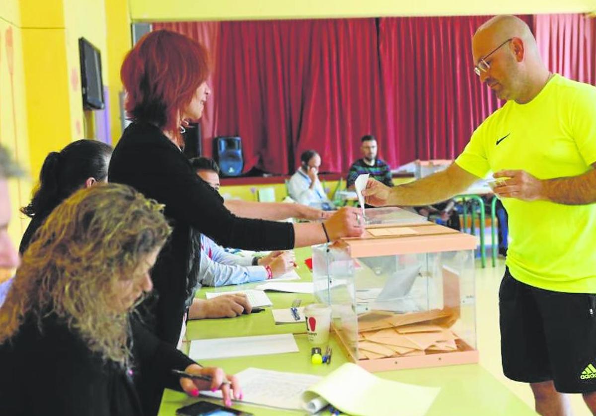 Un vecino deposita su voto en una de las mesas electorales de Colindres.