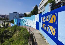 Un tramo del mural artístico de la senda de Mataleñas, donde se aprecia una ola y el diseño de la barandilla de la playa de El Sardinero.