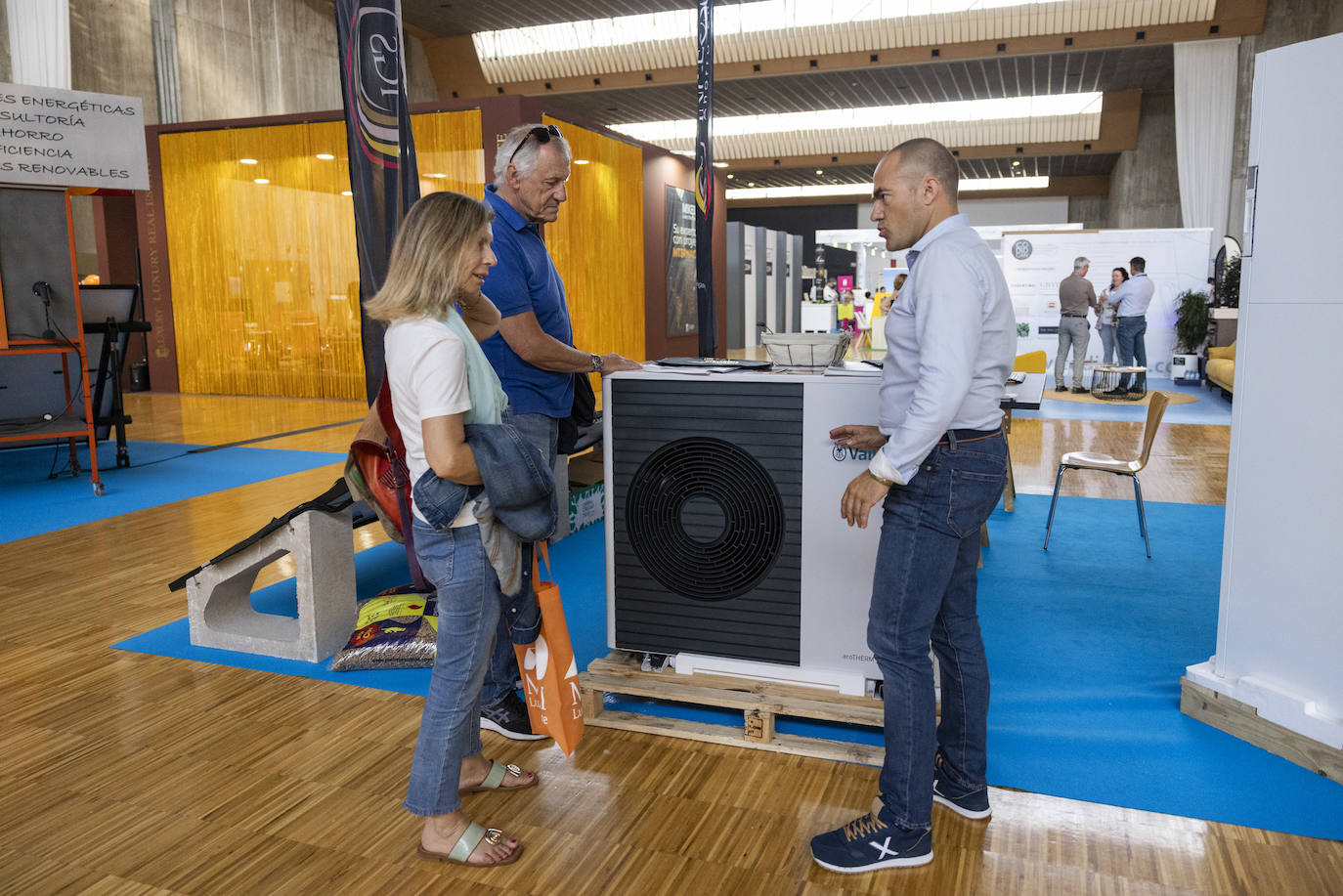 Una pareja de visitantes se interesa por la instalación de aerotermia en Ingeosolar. 