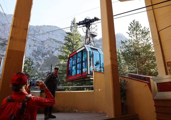 Un turista fotografía a un compañero en la estación de abajo del teleférico.