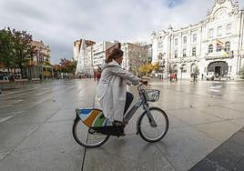 Una mujer pasea por la plaza del Ayuntamiento en una bicicleta eléctrica como las que se pondrán en servicio en Santander