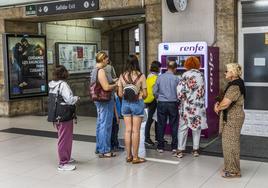 Un grupo de usuarios de la red de Cercanías de Cantabria, sacando el abono de transporte gratuito en la estación de Santander.