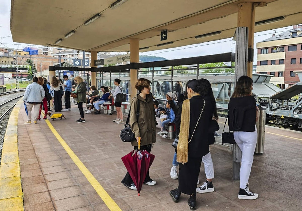 Un nutrido grupo de pasajeros esperando en el andén de Torrelavega al tren con el que se reanudó la circulación.