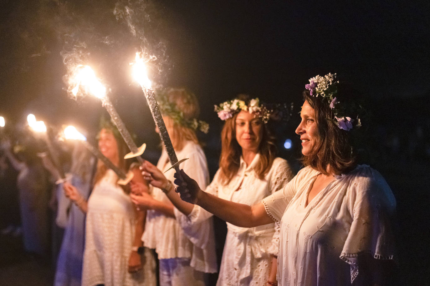 Varias mujeres ataviadas con vestidos y flores en el pelo fueron las protagonistas del desfile de las antorchas.