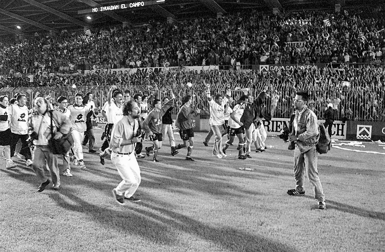 Los jugadores celebran el ascenso sobre el césped de los Campos de Sport ante una grada abarrotada.