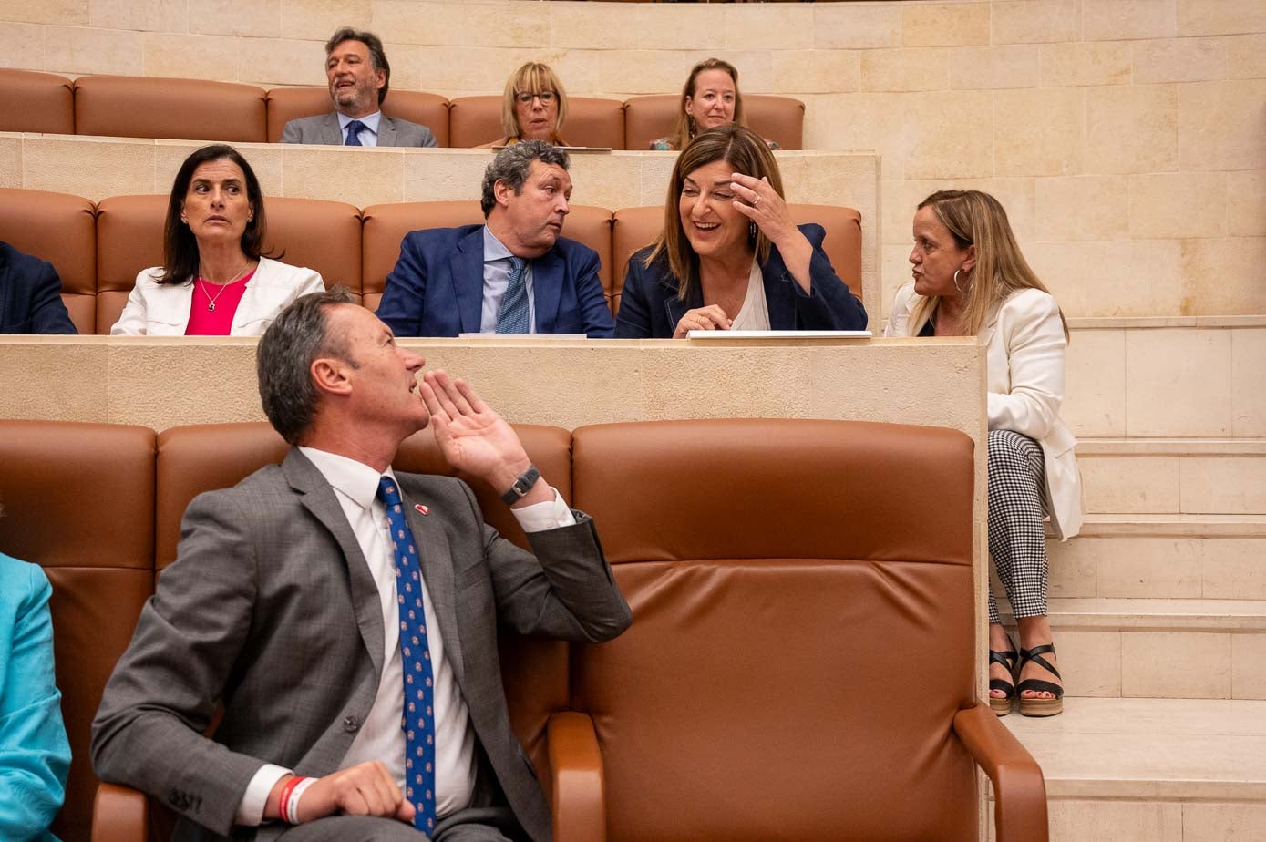 Guillermo Blanco charla con María José Sáenz de Buruaga, sentada junto a Íñigo Fernández y Gema Igual. En las escaleras, sentada, Isabel Urrutia. 