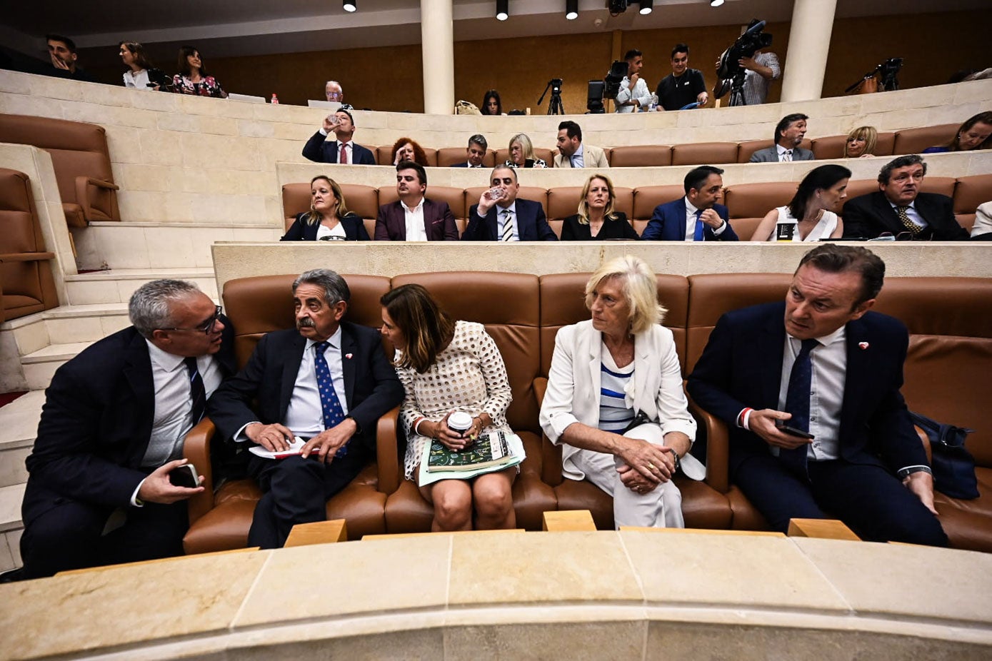 Pedro Hernando habla a sus compañeros de partido. Arriba, los diputados Populares en esta sesión de investidura.