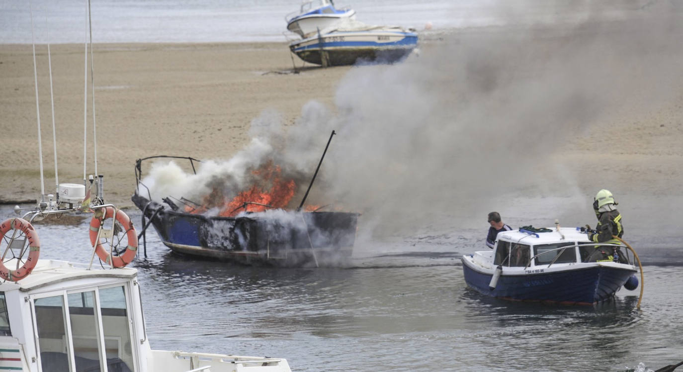 Un pequeño barco particular acercó a los bomberos hasta el que estaba en llamas. 