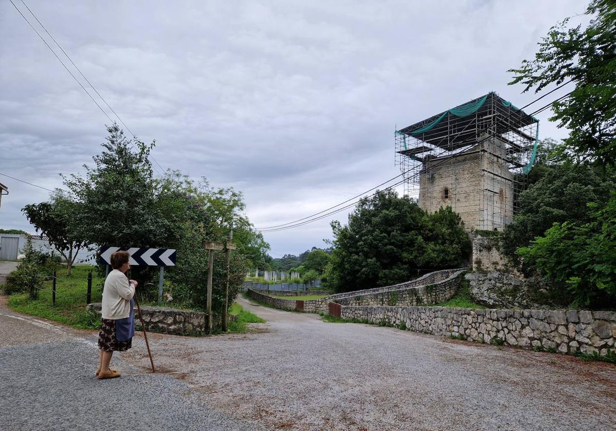 Una vecina ante la Torre de Estrada rodeada de andamios.