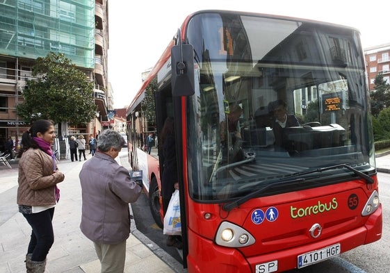 Pasajeros suben a un Torrebús, en Torrelavega.