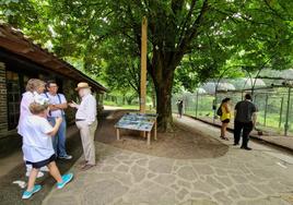 El director del zoo, José Ignacio Pardo de Santayana, conversa con visitantes junto a la placa y las fotos de las inundaciones.