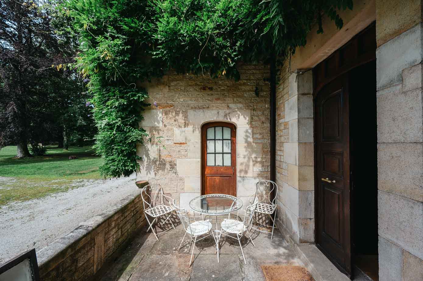 Un rincón de la terraza de la casa, con velador y silla de hierro. 