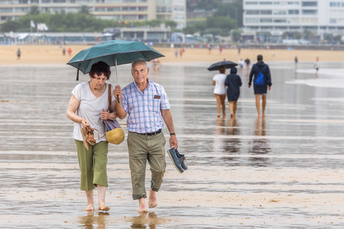 El mal tiempo no desanimó a mucha gente que se descalzó para pasear por la orilla de la playa. 