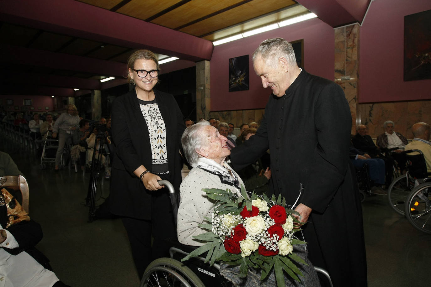 María López Fernández, 101 años, recibe un ramo de flores de manos de Luis López Ormazábal en 2018.