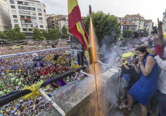 La alcaldesa se protege tras disparar el chupinazo desde el balcón del Ayuntamiento con una plaza abarrotada.