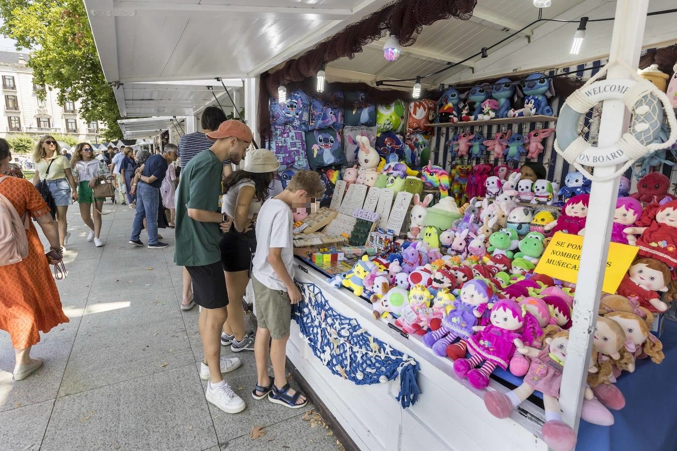 Curiosos observan los productos de uno  de los puestos del Mercado Marinero.