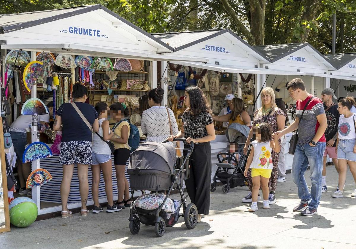 Varias familias paseando por la Plaza Alfonso XIII, donde se encuentran las casetas del mercado.