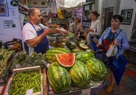 Varios clientes de la frutería El Valenciano, en el Mercado de la Esperanza, hacen cola ayer para comprar.