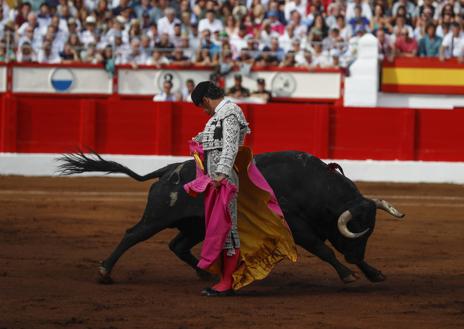 Imagen secundaria 1 - Lance con la rodilla flexionada de Cayetano Rivera a su primer oponente. Chicuelina de Pablo Aguado al tercero de la tarde. Roca Rey, ya sin el vestido de luces, abandona la enfermería del coso. 